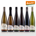 Six bottles of Alsace Vignoble Luc Faller  wines r, arranged in a row against a white background. The bottles have different colored glass (green, gold, dark brown, black) and different colored labels, with the Demeter logo visible in the top right corner.