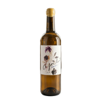 Wine bottle with a decorative label on a table in a wine cellar.