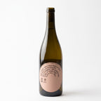 A single dark green glass wine bottle with a pale pink oval label, photographed against a clean white background.