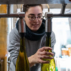 Sarah Lombardi is working with wine bottles on an assembly line at Domaine Les Obrieres