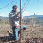 Lluís Arias working with a fence in an open field with mountains in the background