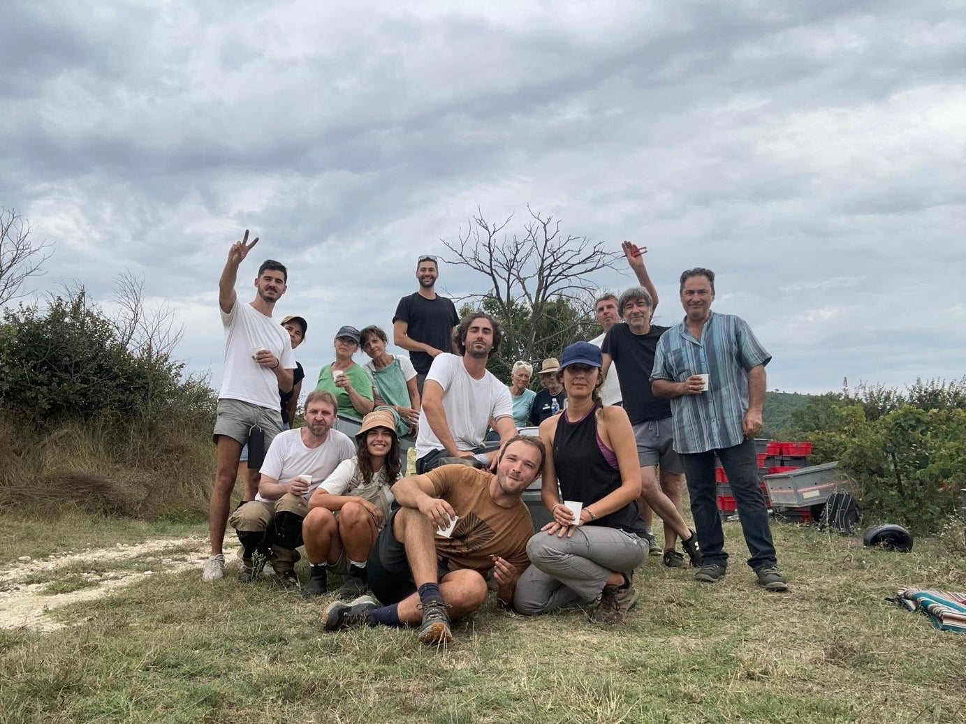 Group of people posing outdoors afer grape harvesting at Malia's