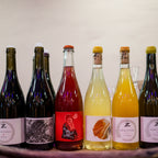 Assorted wine bottles on a wooden tray with a blurred background